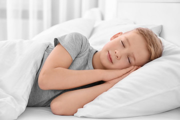 Obraz na płótnie Canvas Cute boy sleeping on white pillow at home