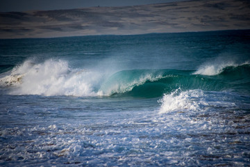 Rolling waves breaking on the beach