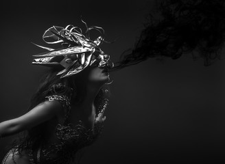 queen, black smoke, brunette woman dressed in goth style with a dress of golden threads and mask with skull