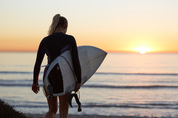 Fototapeta na wymiar Woman with surfboard and shining sun light at the beach