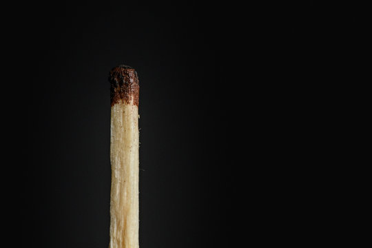 The match is not completely burned, substandard on a black background closeup