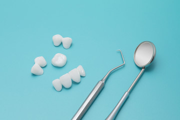 Dental tools and Tooth implant on a Turquoise background