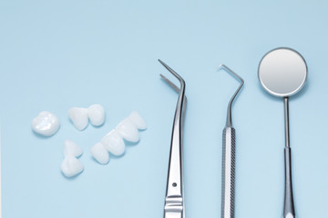 Dental tools and Tooth implant on a light blue background