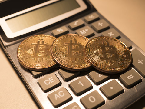 bitcoins and calculator on the table