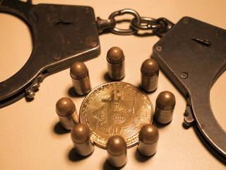 bitcoins and bullets on wooden table