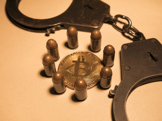 Fototapeta na wymiar bitcoins and bullets on wooden table