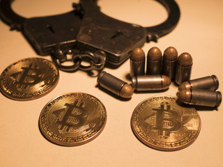 bitcoins and bullets on wooden table