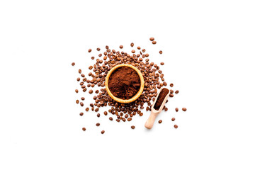 Fresh roasted coffee beans in bowl and scoop on white table top view copyspace. Coffee background.