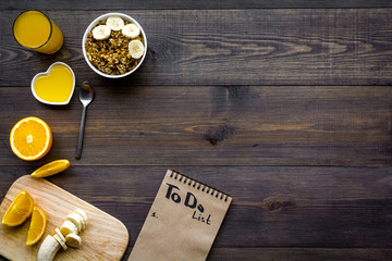 Good morning habits. Eat porridge and fruits and make to do list. Dark wooden background top view...