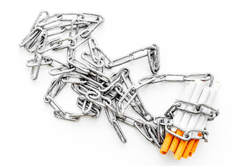 Quit smoking. Cigarettes in chains on white background top view