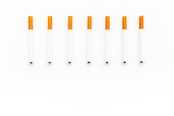 Tobacco. Row of cigarettes on white background top view copyspace