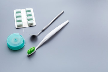Tools for oral cavity hygiene. Brushes, floss, dental mirror, gum on blue background copyspace