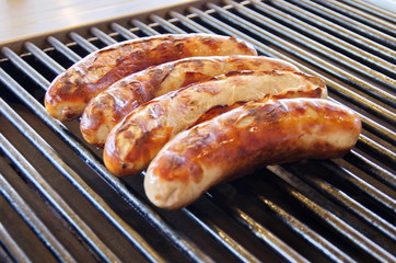 Vier Bratwürste auf dem Grill