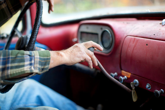 Close up of man holding gearshift while driving a pickup truck