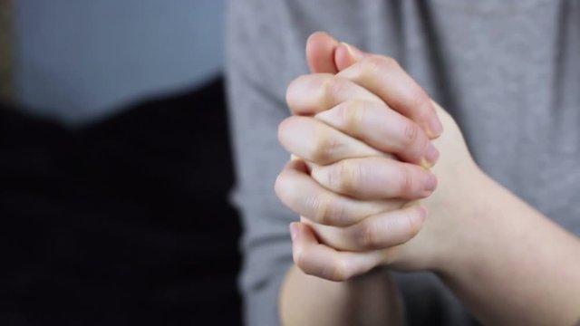 Close-up of women's hands pray.