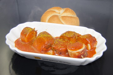 Schale mit Currywurst und Brötchen