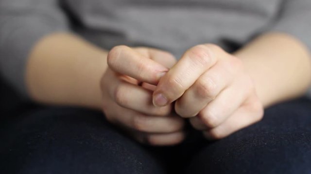 Close-up of wringing nervous woman hands.