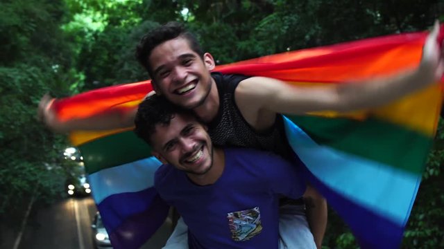 Couple piggybacking with rainbow flag