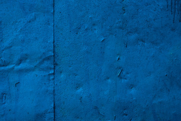 Old iron surface is painted with blue paint - bright rustic metal background