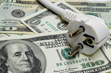 White power plug lying on american dollars