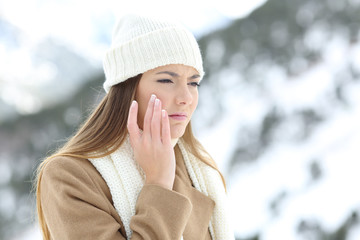 Angry woman using a sking protection cream in winter