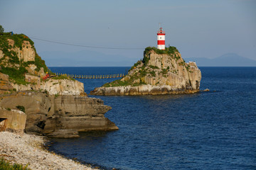 Fototapeta na wymiar Lighthouse at Cape Basargin, Golden Horn Bay, Vladivostok symbol. Russky island. Landscape panorama. Sea of Japan.