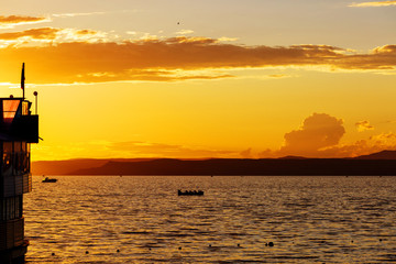 A rowing boat floating on the sea during sunset