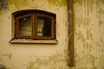 stara ściana z odlatującą farbą z oknem i rynną © Robert