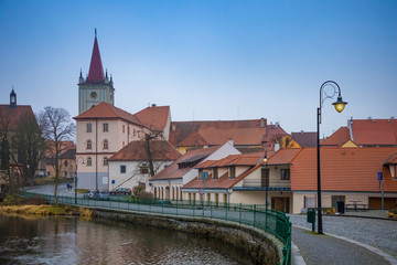 Obraz premium Small town Blatna on embankment of river Lomnice in evening time, Czech Republic