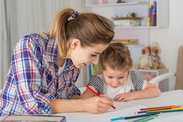 Mother is engaged with daughter.  They draw.