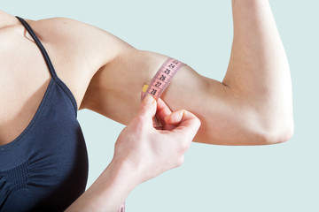 A woman measuring the volume of the arm, biceps