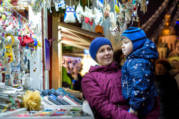 Happy family spend time at a Christmas street market fair in the old town of Salzburg, Austria. Holidays, , concept. Mother and son winter outdoor among decorations