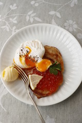 Salmon caviar and egg poached on a pancake made of wholemeal flour.