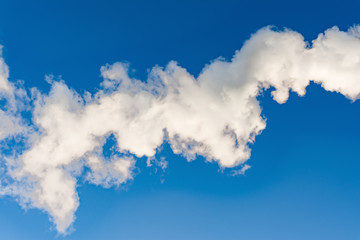 thick white smoke on a background of blue sky