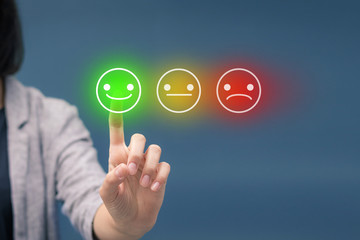 Evaluating customer service satisfaction. Woman pressing happy smiley face emoticon on touch screen.
