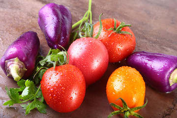 assorted vegetable with purple exotic color bell peppers and tomatoes isolated on stone background.