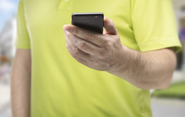 close-up view of man on street with black smartphone in his hand