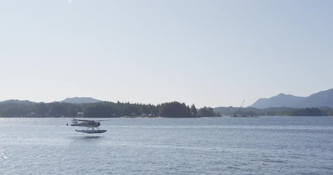 Seaplane landing in Alaska Inside Passage in Ketchikan harbor. Floatplane aka float or sea plane with tourists on sightseeing tour flying in. Alaska tourism and travel. RED EPIC SLOW MOTION.