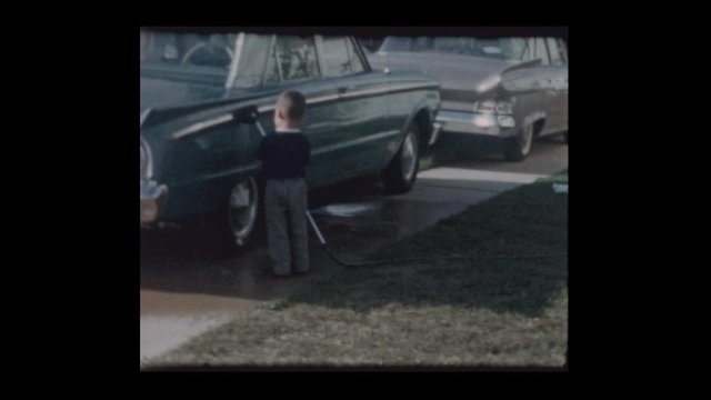 1963 3 year old Little boy washes antique car