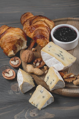 Assorted cheese on round wooden board plate wood background