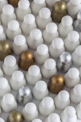 Playful Concepts: Gold, Silver and Bronze game pieces in a crowd of white pieces
