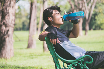 A man fresh up himself after exercise by drinking fresh water.