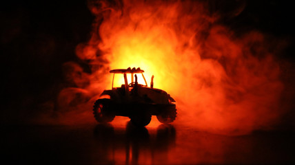 Silhouette of tractor at night with dark foggy background. Toned. Burning vehicle.