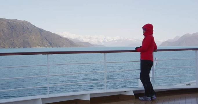 Glacier Bay Alaska cruise ship passenger looking at Alaskan mountains exploring Glacier Bay National Park, USA. Woman on travel sailing Inside Passage enjoying view of Johns Hopkins Glacier.