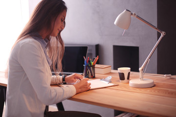 Young female working sitting at a desk. Businesswoman. Drawing. Student. Workplace. Desk.