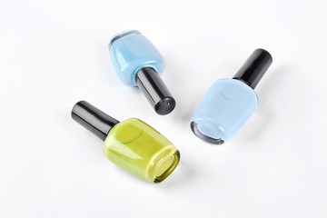 Three multicolored nail polish. Blue, light blue and yellow nail varnish isolated on white background.
