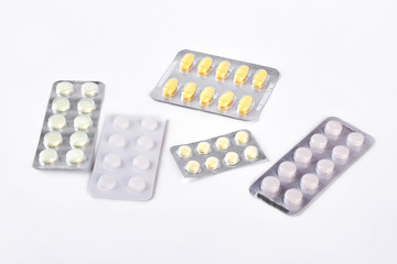 Medicine in blisters, white background. Different types of medical pills in blister pack on white background. Medicine, health care and pharmacy concept.