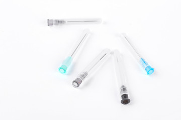 Fototapeta premium Medical syringe needles, white background. Group disposable hypodermic syringe needles over white background, top view. Medicine and medical equipment.