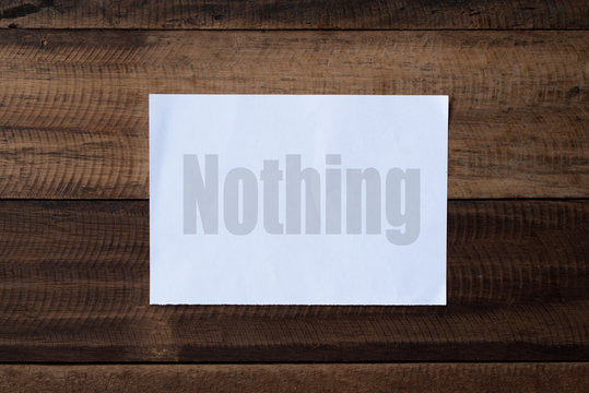 nothing word on paper.piece of paper written "nothing" on a wooden table background