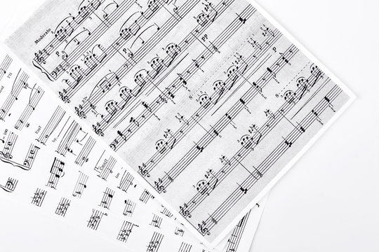 Musical notes on white background. Sheets with musical notes on white background. Music and composition concept.